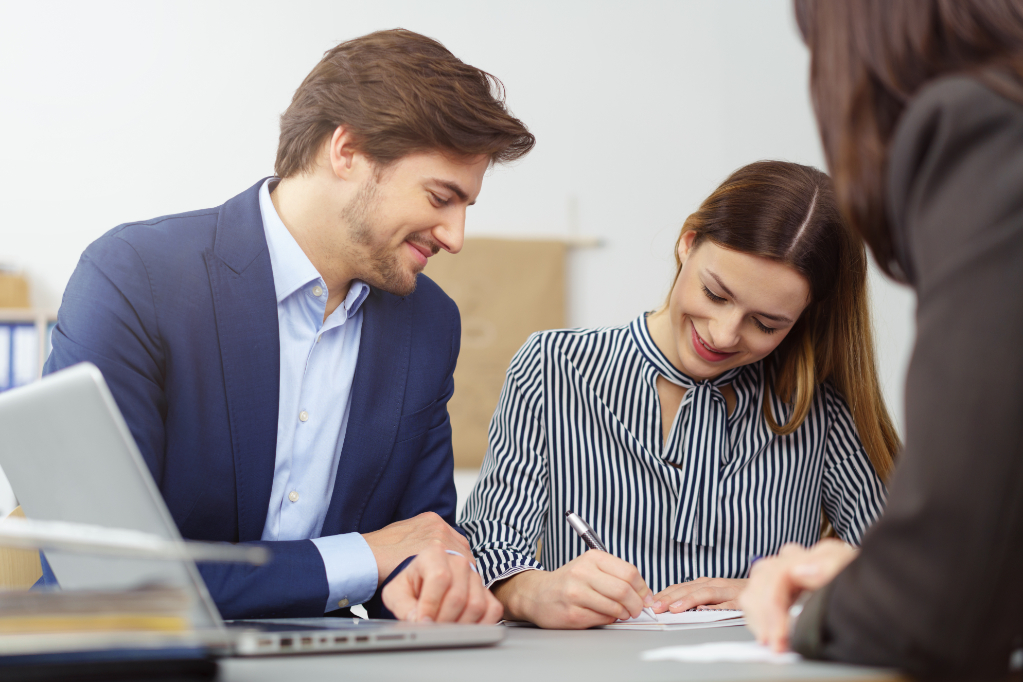 Married couple on meeting with broker at office, signing papers